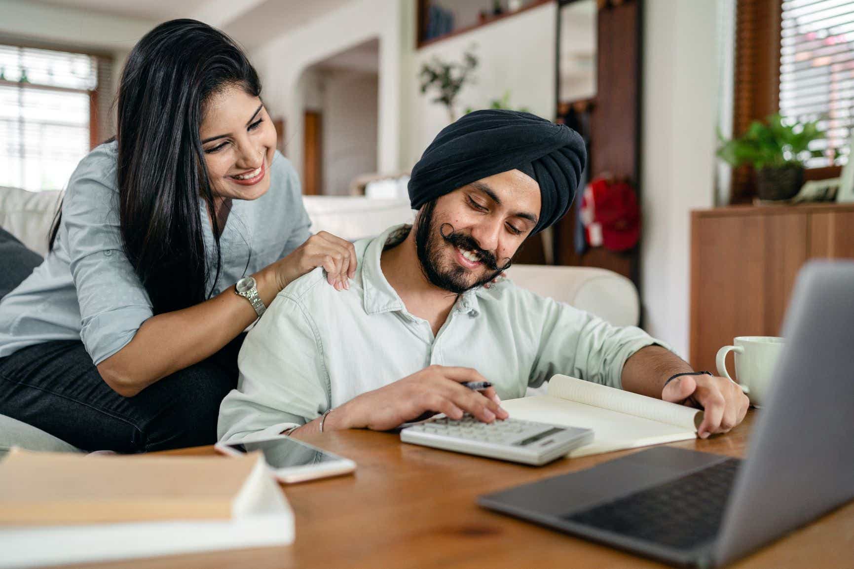 a man and a woman looking at laptop